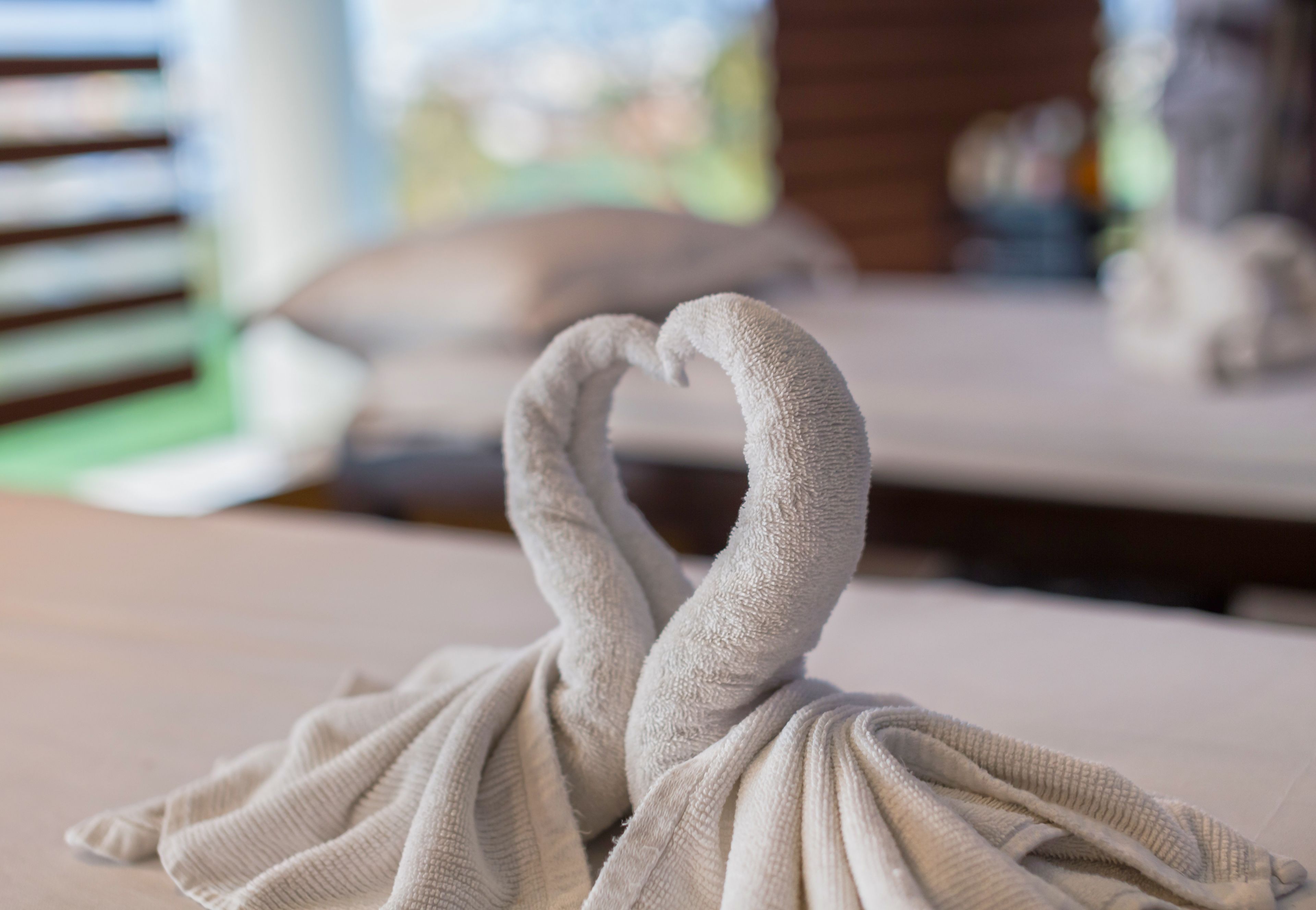 A towel arranged in the shape of a swan on a white surface.