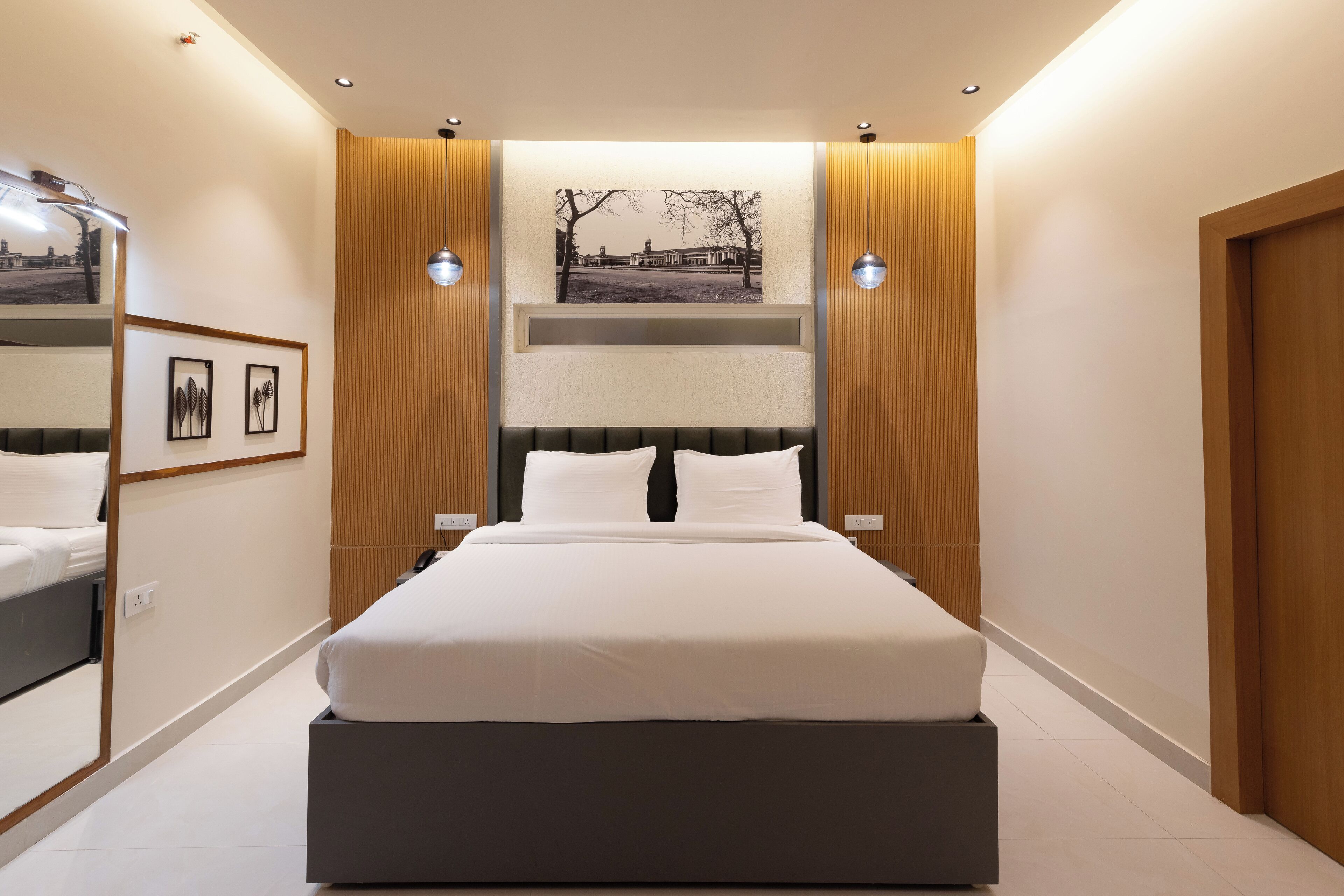 Un dormitorio moderno con una cama grande, paneles de madera y un cuadro enmarcado en la pared.