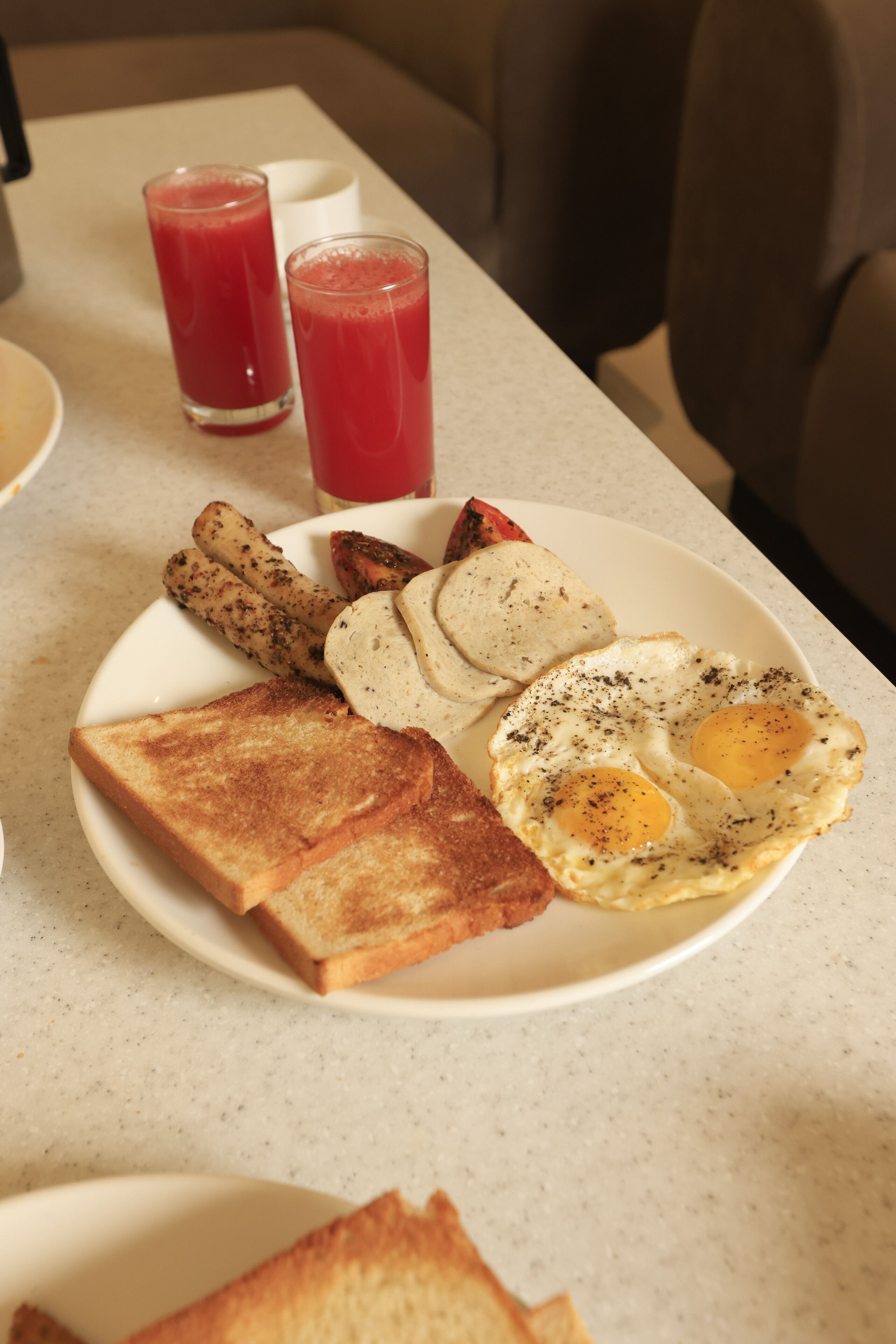 Ein Frühstücksteller mit Toast, Eiern und Speck.