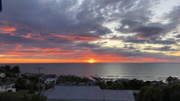 Vista del atardecer en la costa, con casas y cielo despejado.