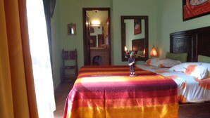 Une chambre d’hôtel avec un lit, une chaise, un miroir et un tableau au mur.