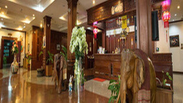A lobby with wooden decor, a reception desk, and potted plants. - Angkham Hotel (Vientiane)