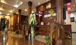 A lobby with wooden decor, a reception desk, and potted plants. - Angkham Hotel (Vientiane)