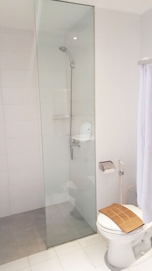 A modern bathroom with a glass-enclosed shower, a white toilet, and a towel rack. - Centro City Service Apartment (Jakarta)