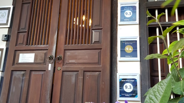 A wooden double door with a sign above reading "Betel Hut Lodge".