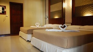 A hotel room with two beds, each with a heart-shaped towel arrangement. - Staylite Hotel (Candon)