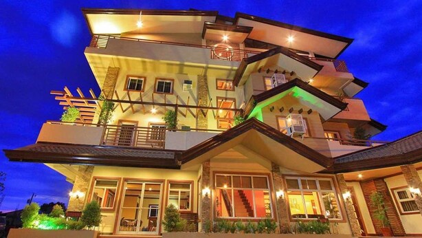 A multi-story building with a unique architectural design, featuring balconies and large windows. - Staylite Hotel (Candon)