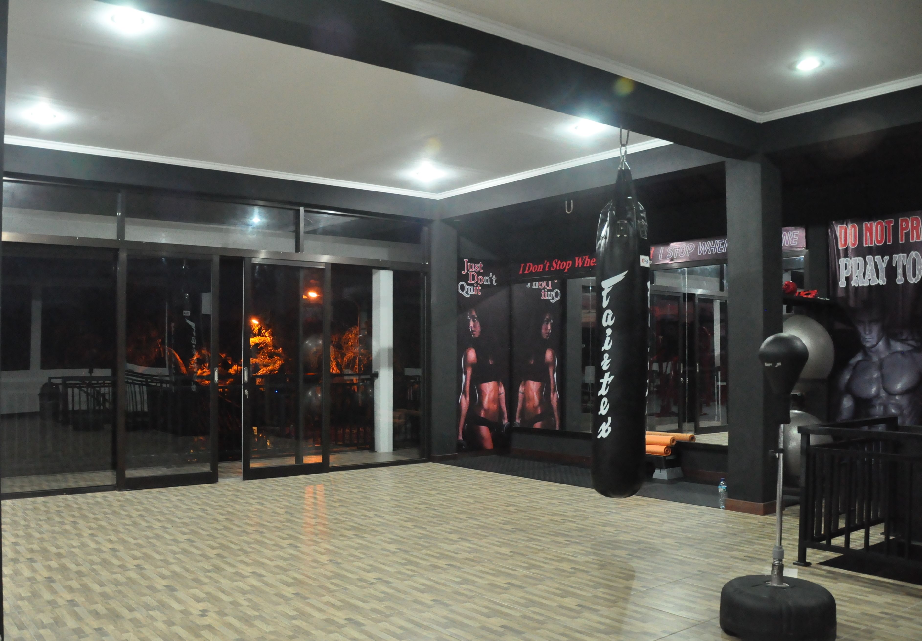 A gym with a punching bag, exercise equipment, and motivational posters on the walls.