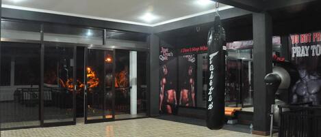A gym with a punching bag, exercise equipment, and motivational posters on the walls.