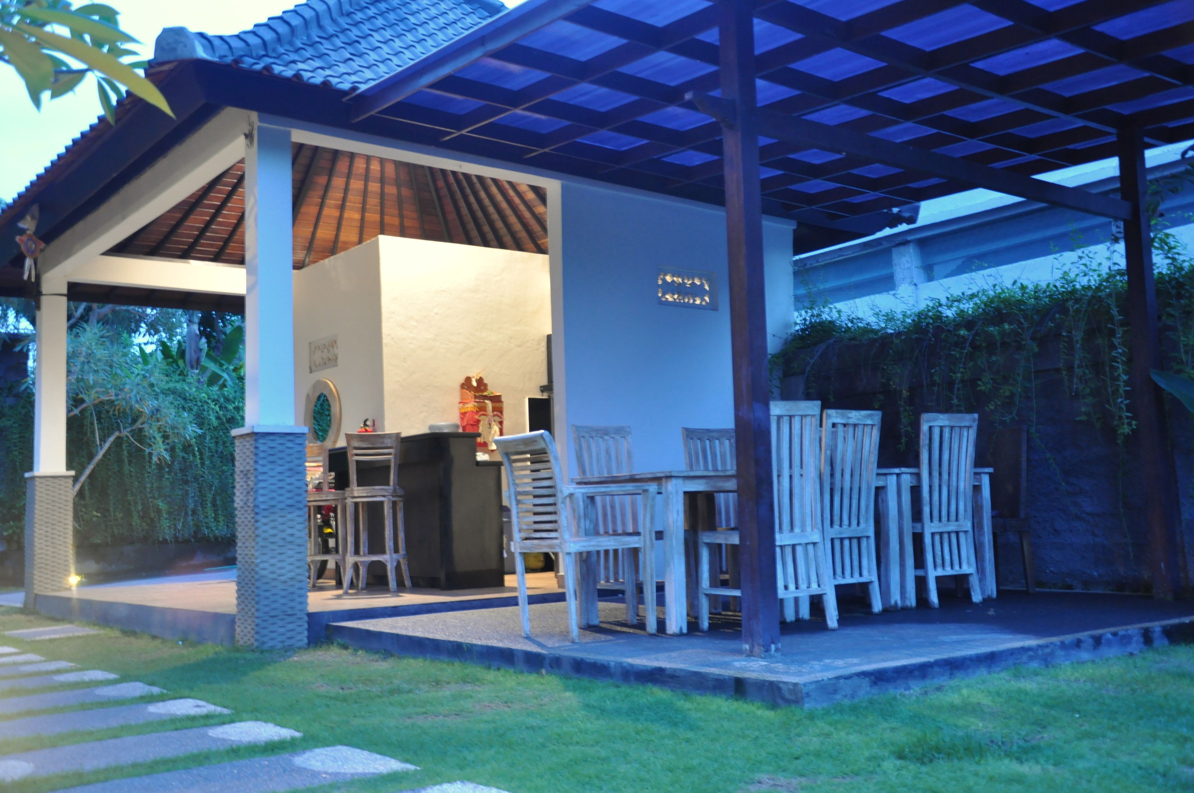 An outdoor covered patio with a dining area, a bar, and a sign indicating a restaurant.