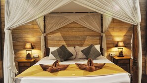 A bed with a canopy, two bedside lamps, and a wooden headboard. - Kubudiuma Villas (Pererenan)