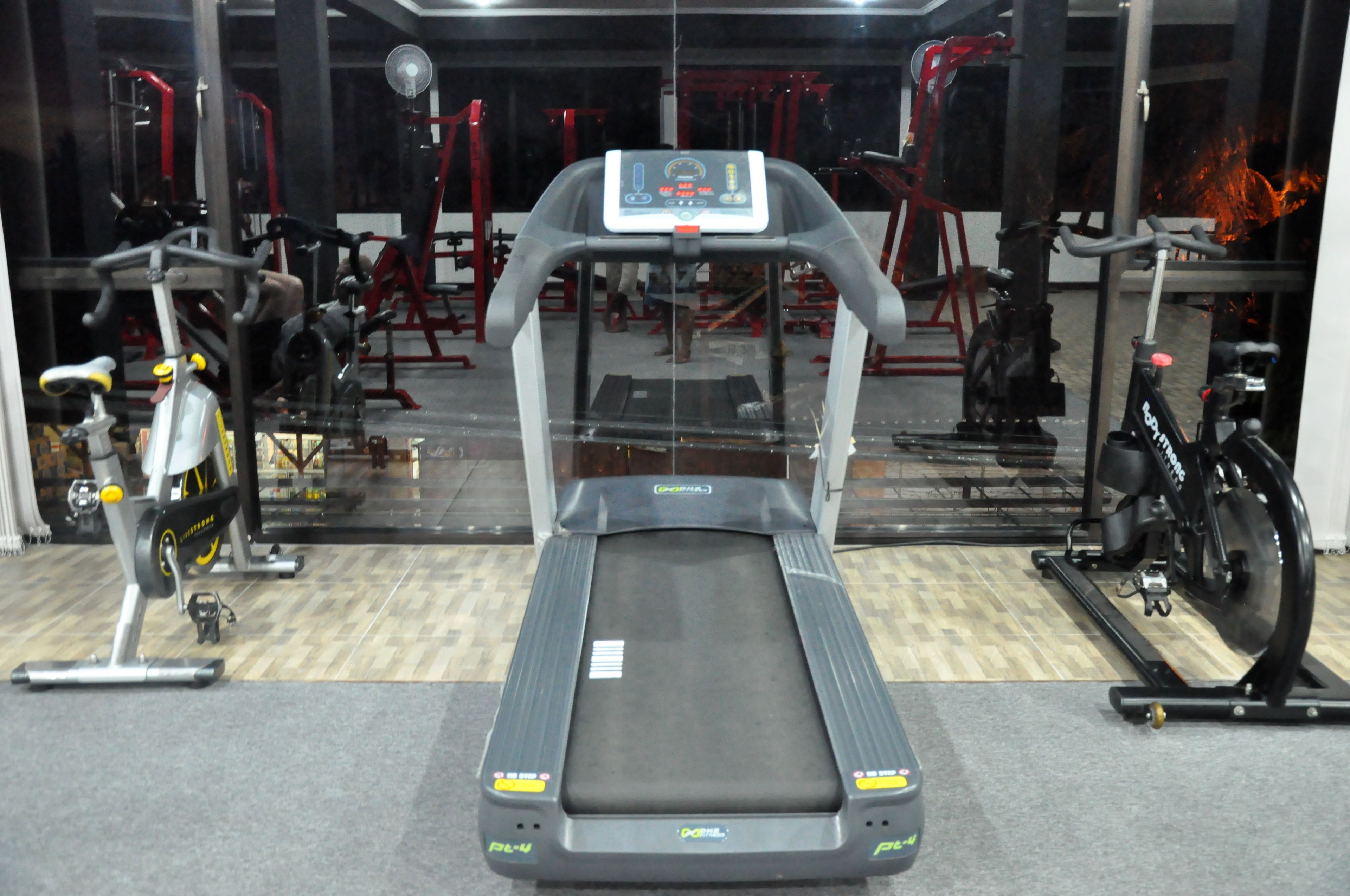 A gym with a treadmill, stationary bikes, and various exercise machines.