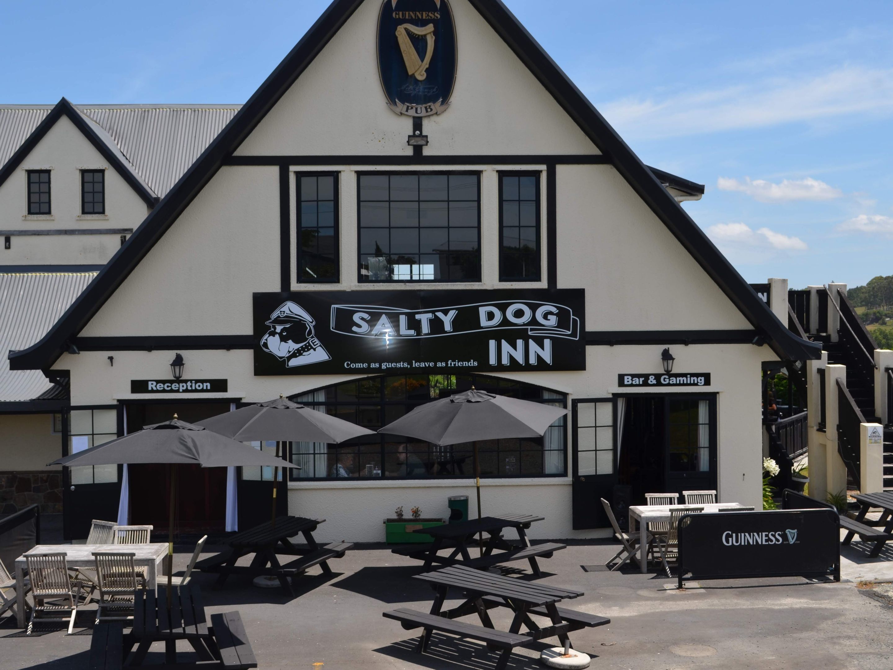 Un bâtiment sur lequel on peut voir une enseigne indiquant « Salty Dog Inn » et, au-dessus, une autre enseigne représentant un pub Guinness.