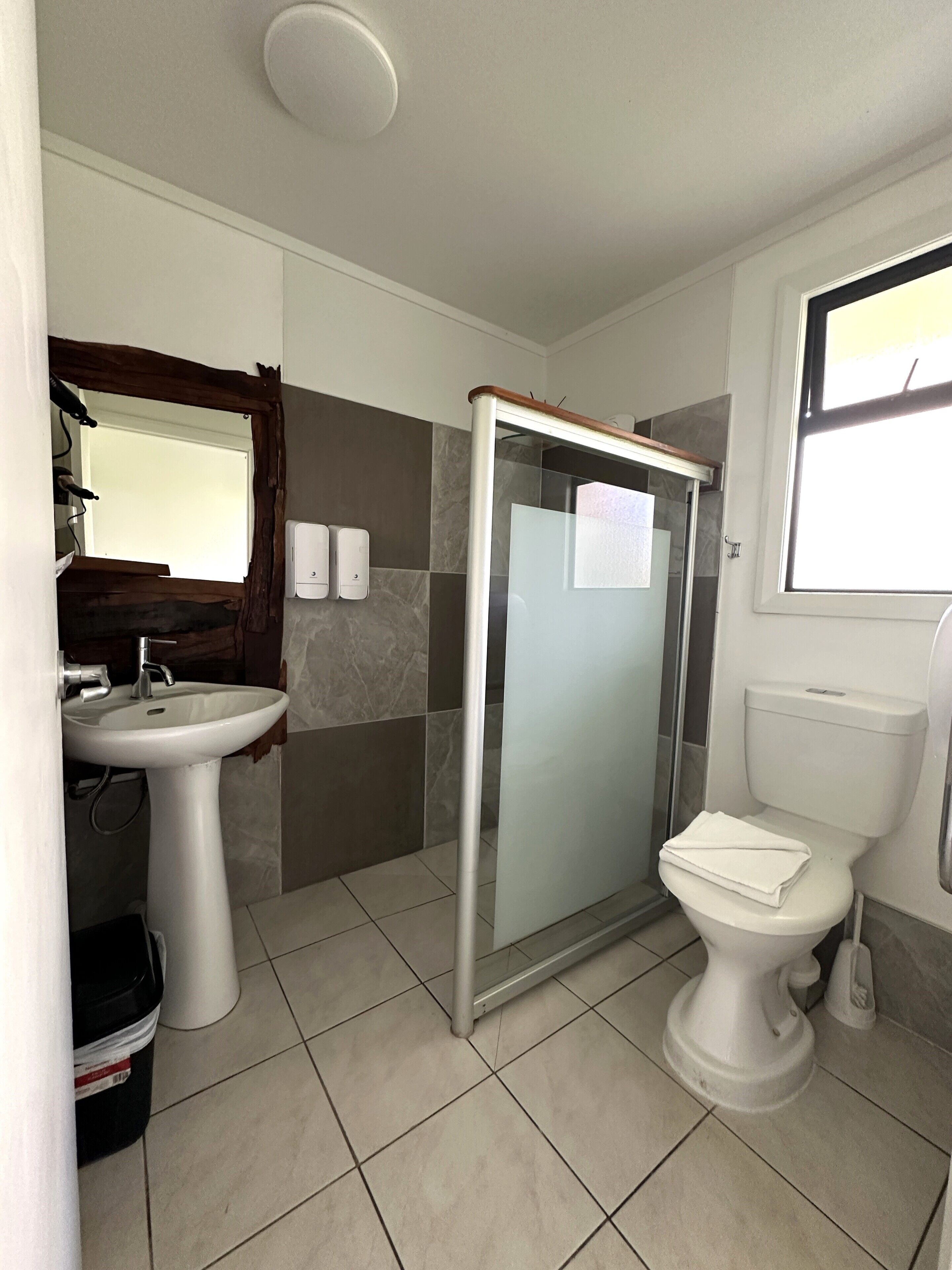A bathroom with a sink, toilet, and shower.