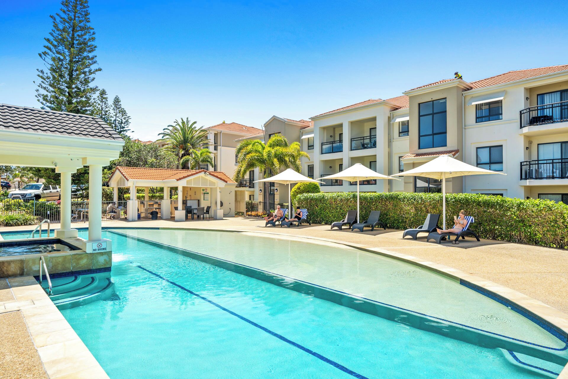 2 つの屋外プール、プール パラソル、サンラウンジャー