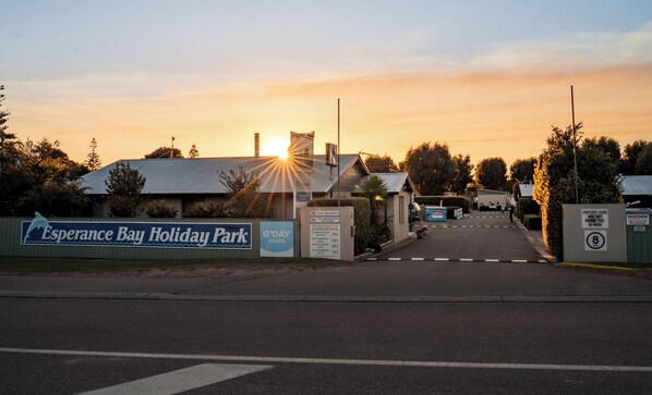 A gated entrance to a holiday park with a sunset in the background. - Esperance Bay Holiday Park (Esperance)