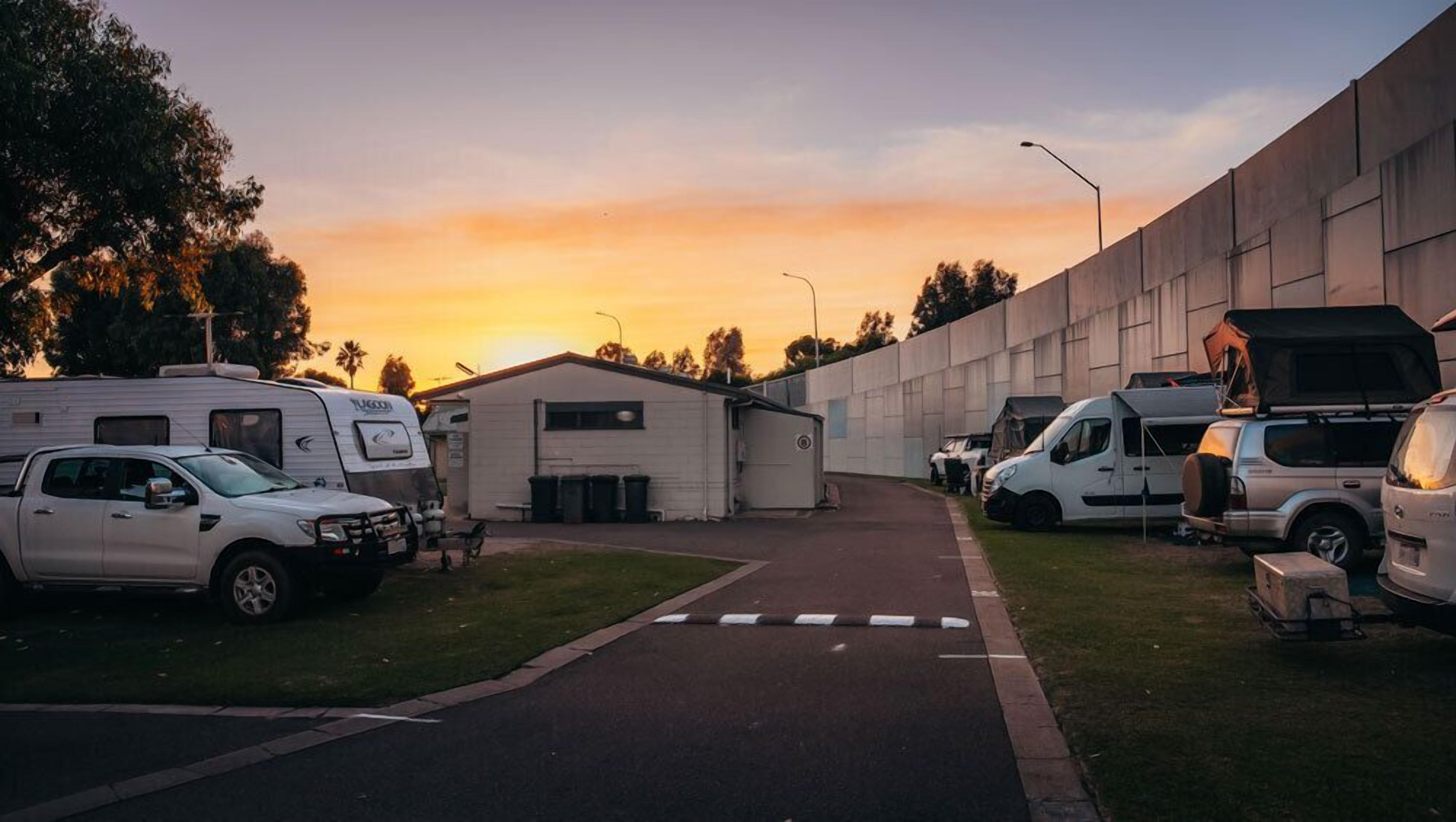 A campsite with RVs and a small building, likely a utility or storage shed, during sunset.