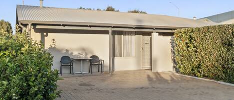A modern building with a flat roof, a covered entrance, and a paved driveway.