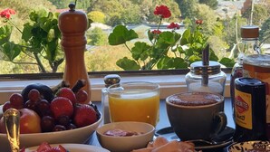 A breakfast table with various foods and a scenic view of a lake and mountains. - Troldhaugen Lodge - Adults Only (Jindabyne)