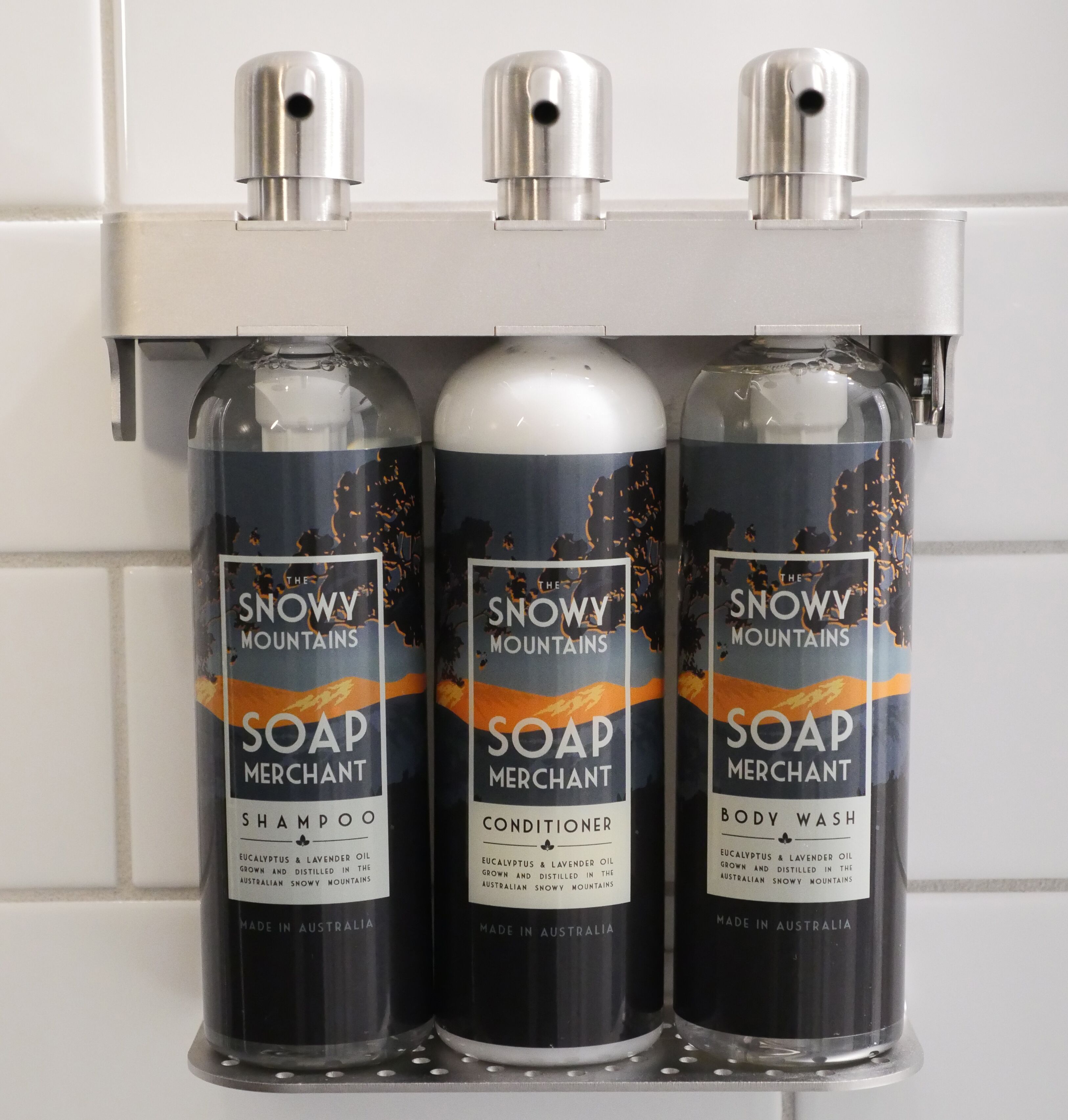 Three bottles of Snowy Mountains soap products on a bathroom shelf.