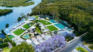 An aerial view of a resort with multiple buildings, a swimming pool, and a marina with boats.