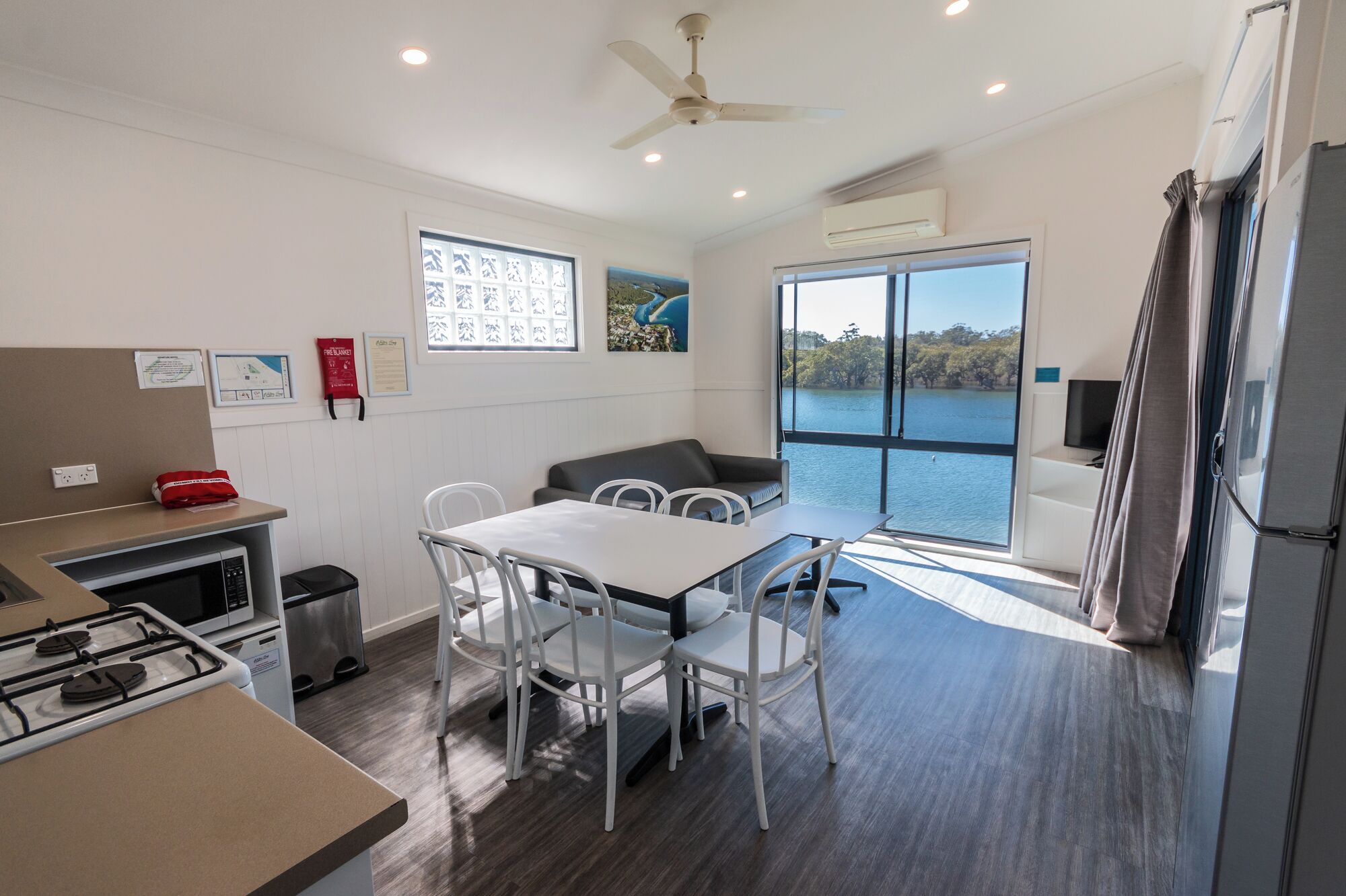 Una cocina moderna con comedor, vistas a un lago y un ventilador de techo.