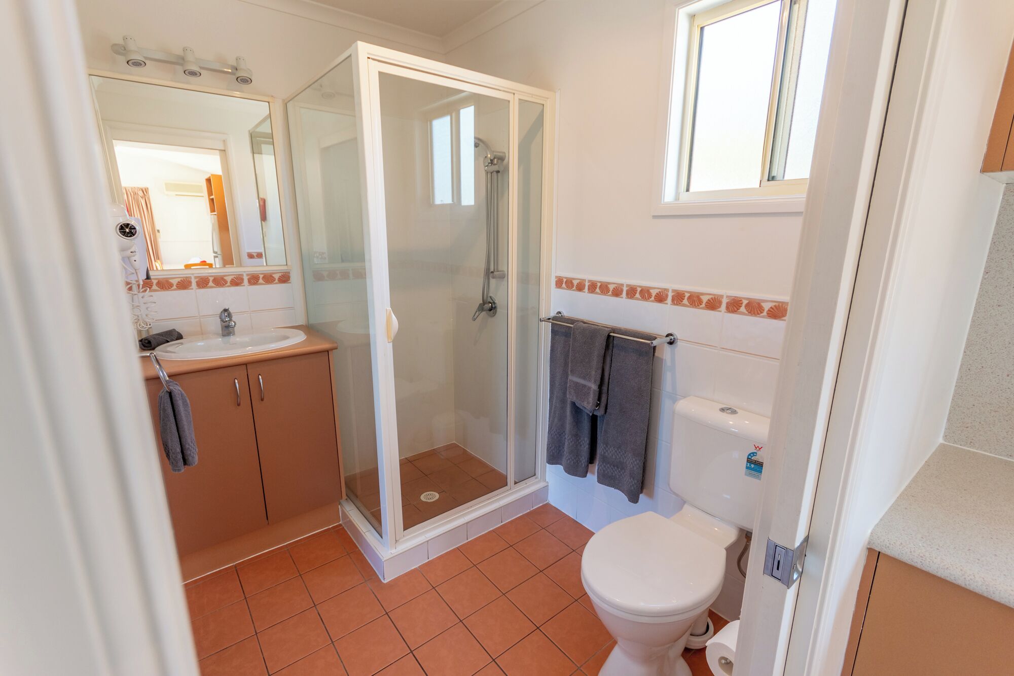 A bathroom with a shower, toilet, and sink.