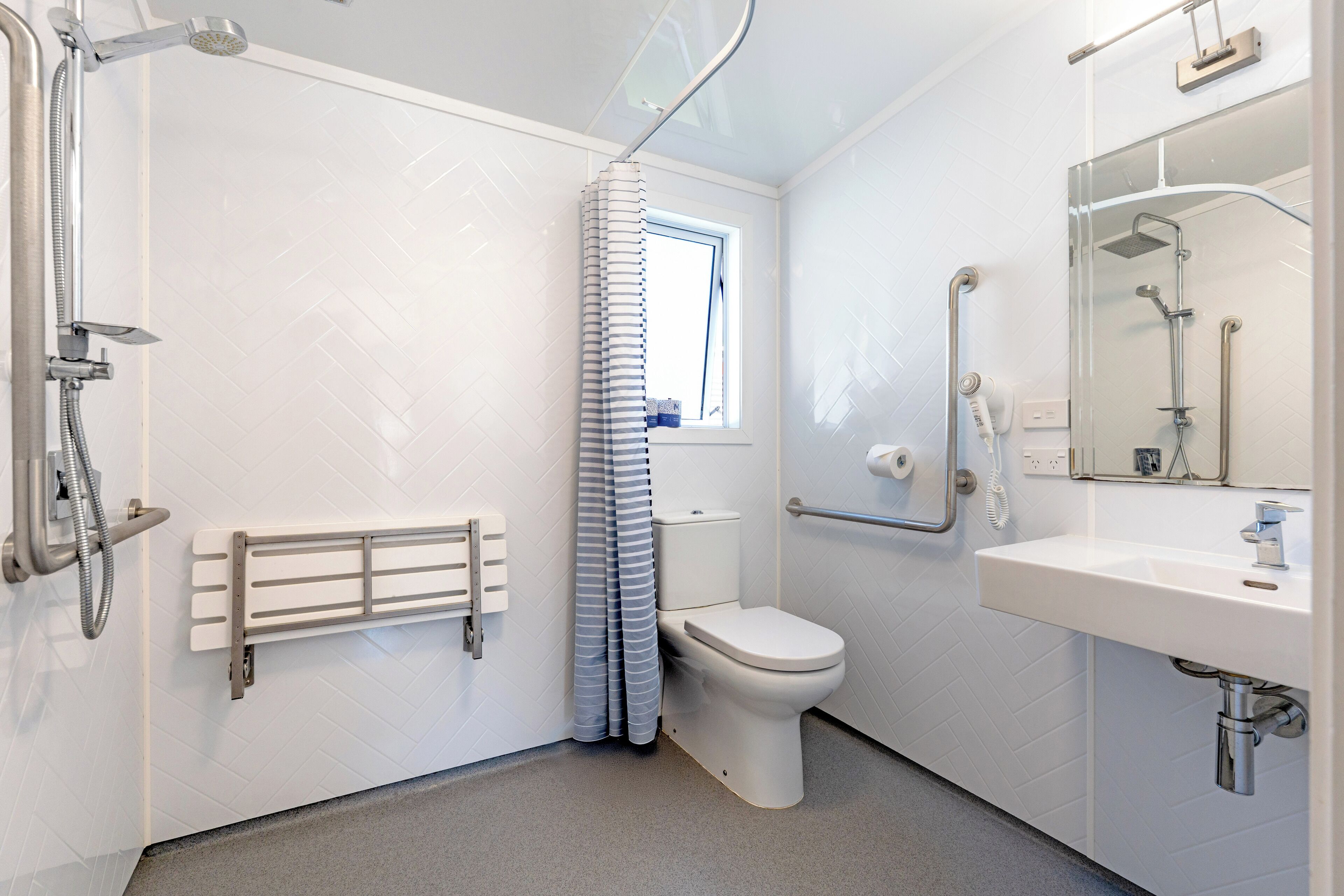 A modern bathroom with a shower, toilet, and sink.