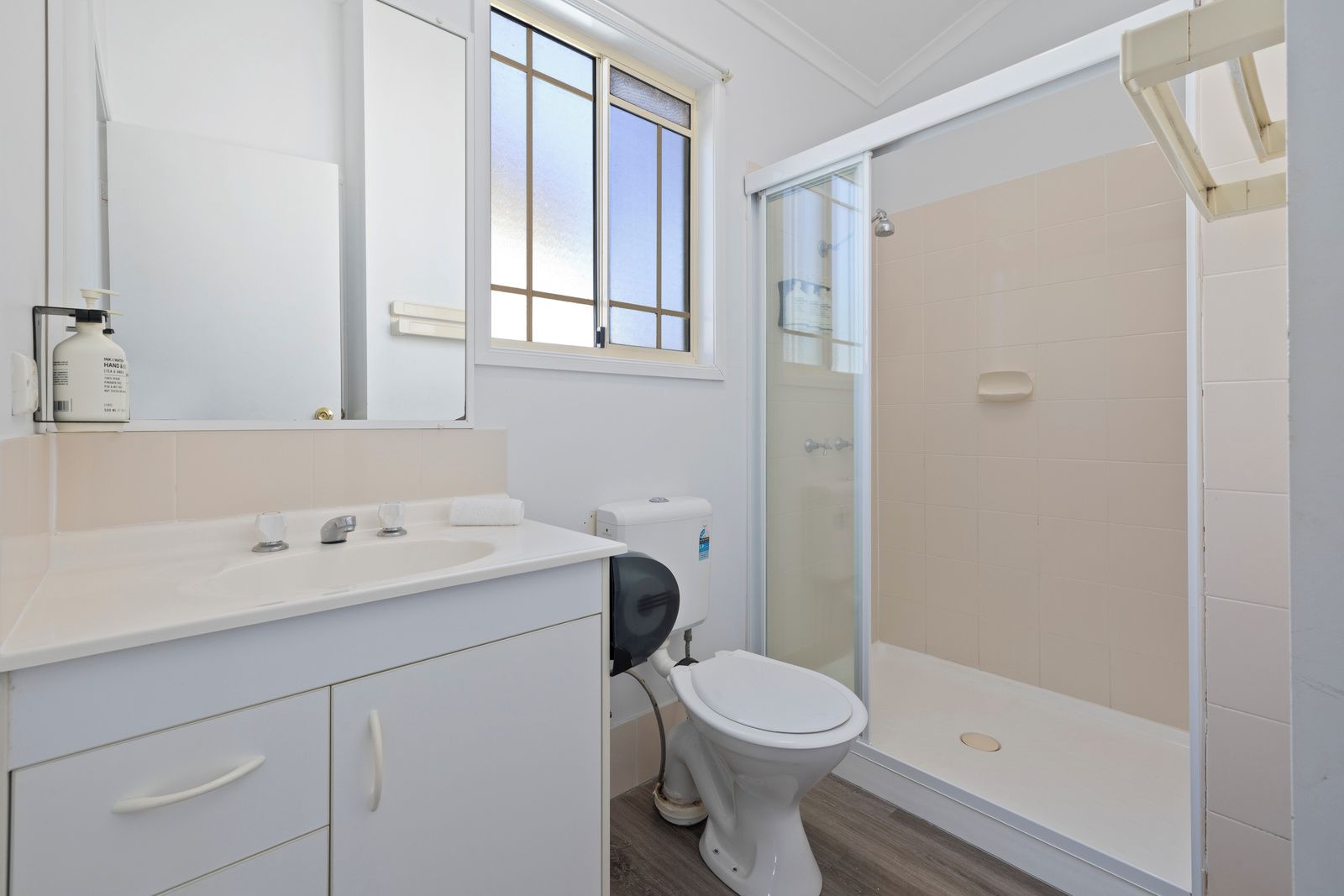 Une salle de bain comprenant des toilettes, un lavabo et un espace douche.