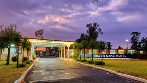A motel with a covered entrance, a sign indicating WiFi availability, and a sign for the Silver Oaks Motel. - Silver Oaks Motel (Gilgandra)