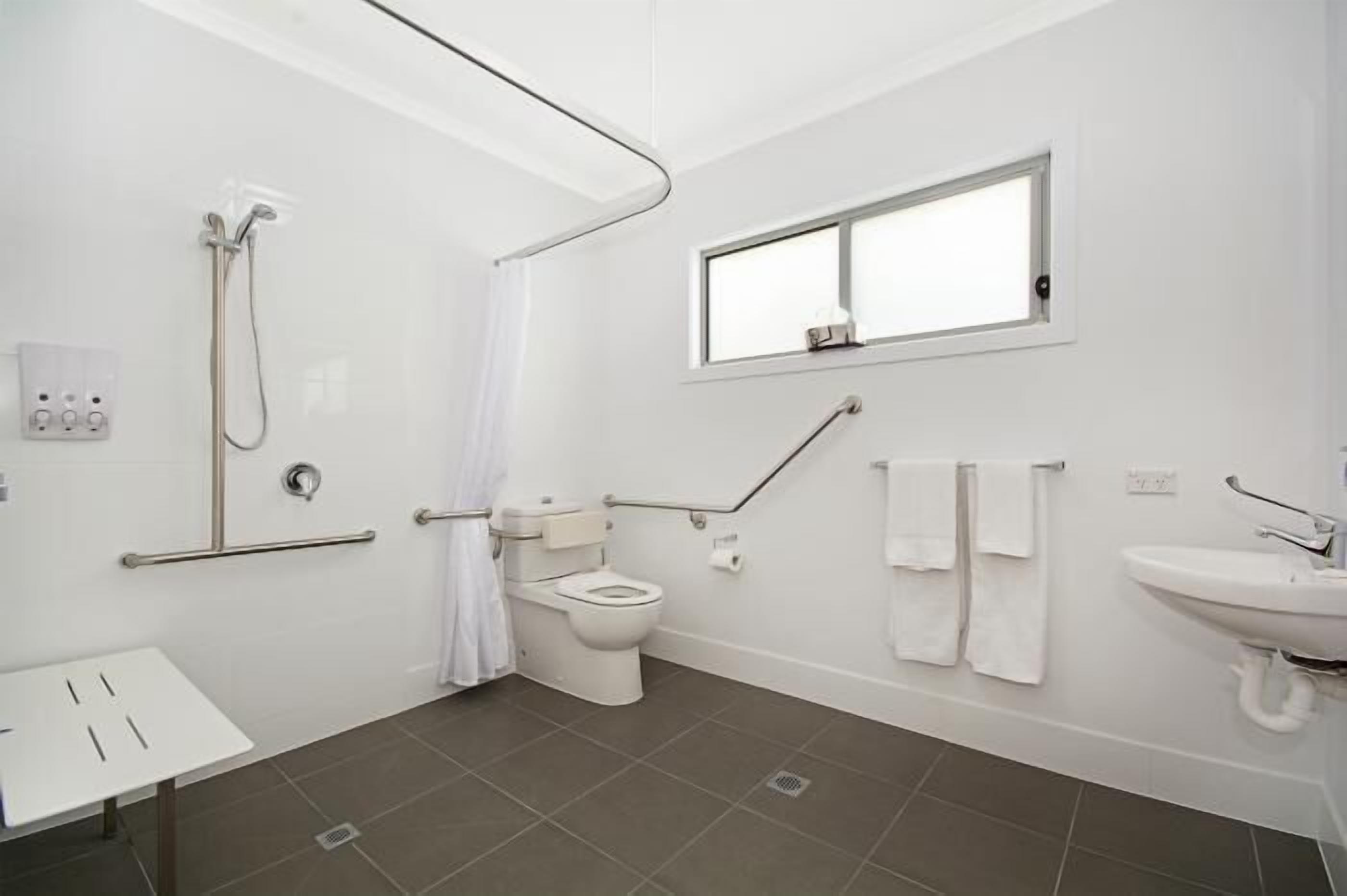 Un bagno moderno dotato di doccia, WC e lavandino.