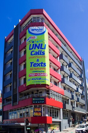 A multi-story hotel with a prominent billboard advertising UNLI calls and texts. - Baguio City Center Hotel (Baguio)