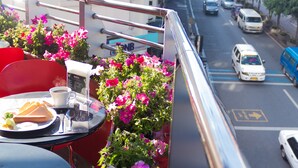 A balcony with a table, chairs, and flowers. - Baguio City Center Hotel (Baguio)