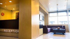 A reception area with a reception desk, a sofa, and a coffee table. - Baguio City Center Hotel (Baguio)