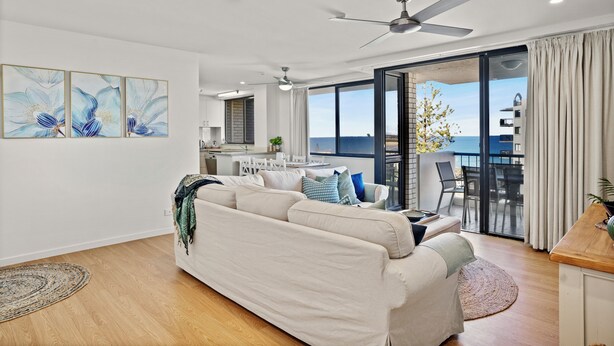 Un salon moderne comprenant un canapé, un coin repas et une vue sur la mer.