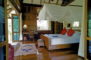 Ein Schlafzimmer mit Baldachinbett, Schreibtisch und Stuhl.
