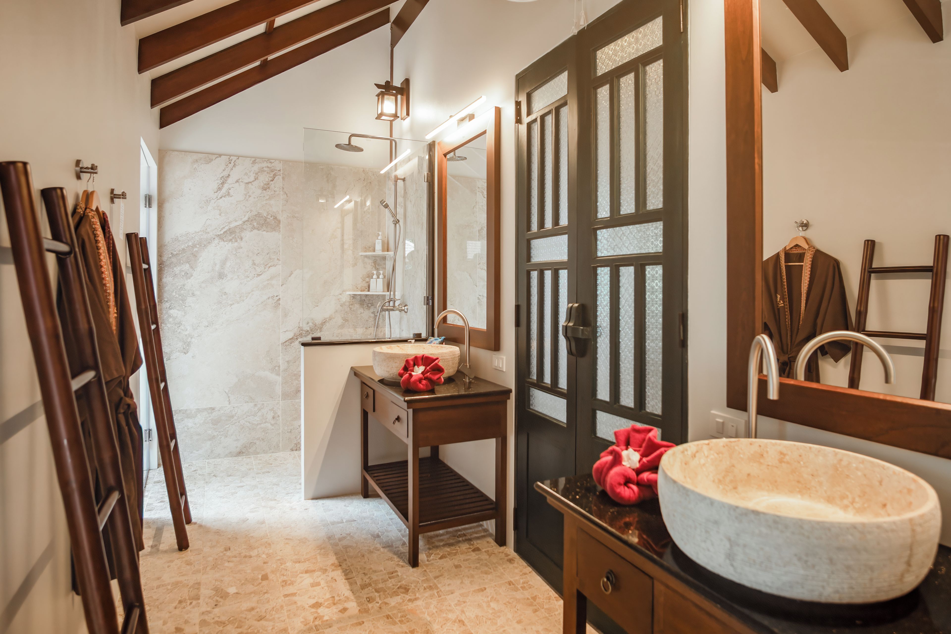 A bathroom with a marble sink, wooden vanity, and a large mirror.