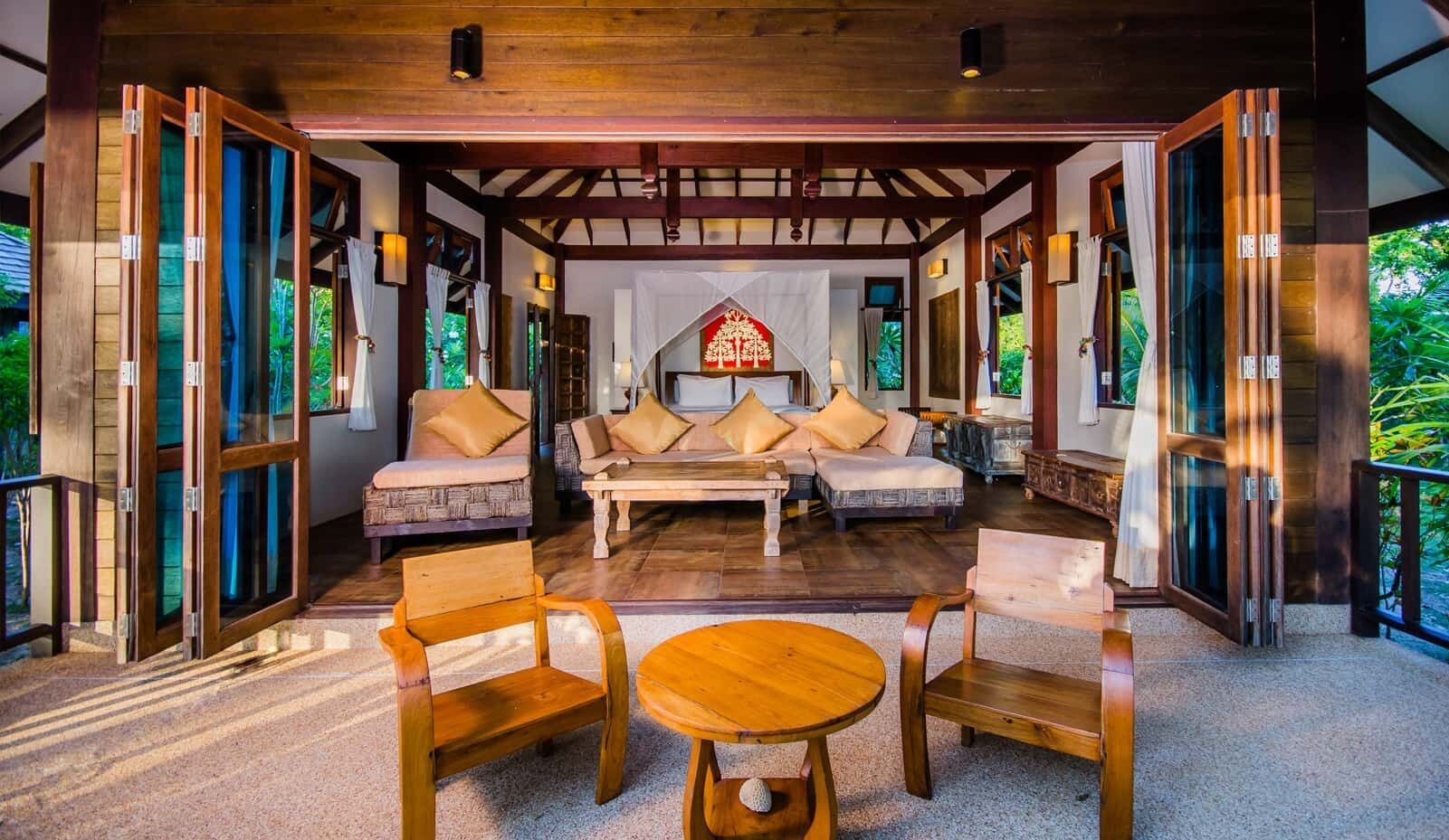 An open-plan living area with a sofa set, a coffee table, and wooden chairs.