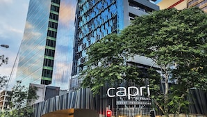 A modern hotel with a glass facade, a prominent entrance, and outdoor seating. - Capri by Fraser, Brisbane (Brisbane)
