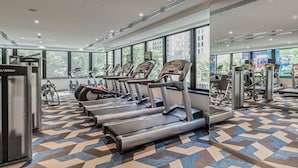 A modern gym with treadmills, ellipticals, and weight machines. - Capri by Fraser, Brisbane (Brisbane)