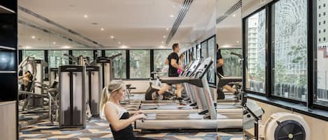 A gym with treadmills, exercise bikes, and a rowing machine.