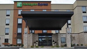Ein Holiday Inn Express Hotel mit moderner Fassade, überdachter Zufahrt und Parkplatz.