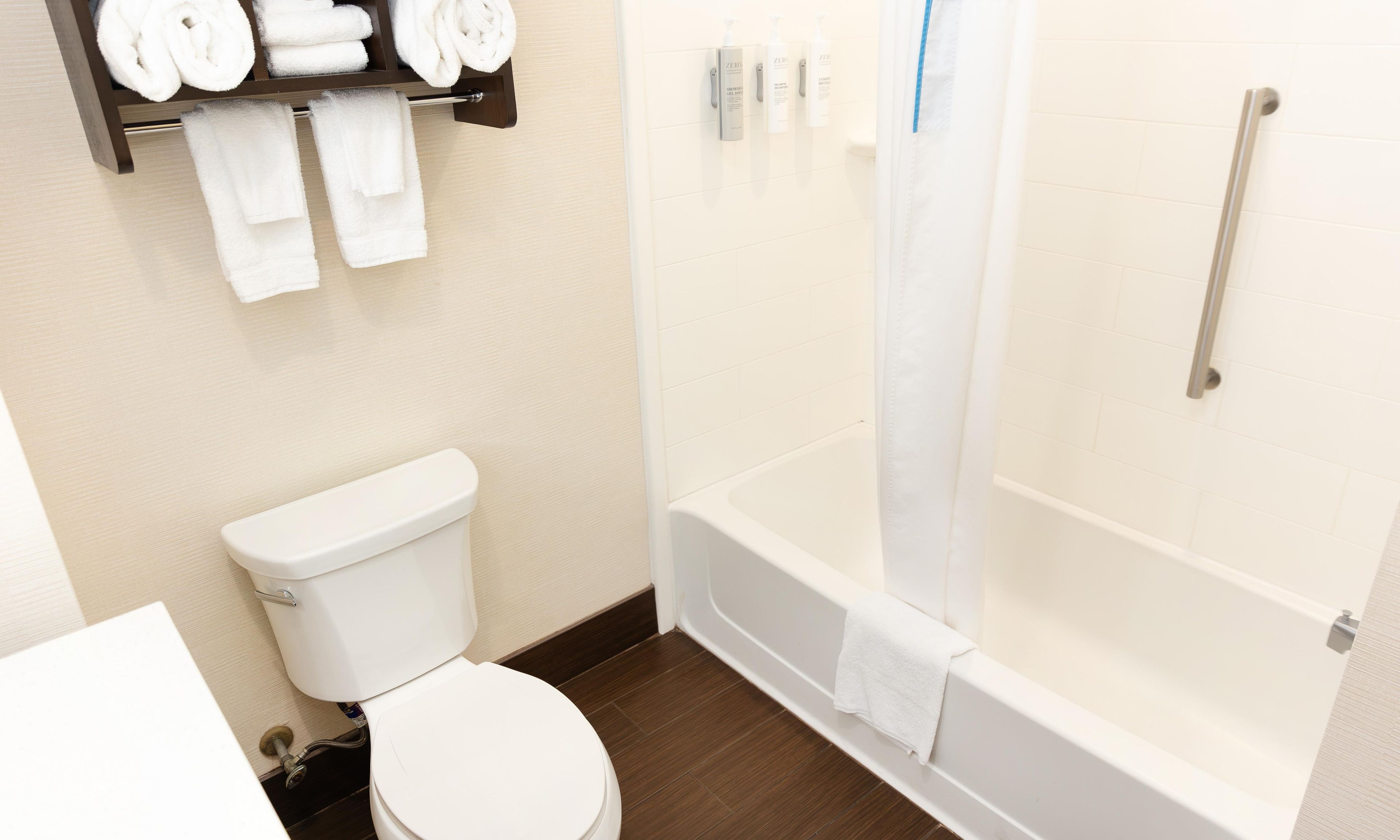 A bathroom with a toilet, a bathtub, and a shower curtain.