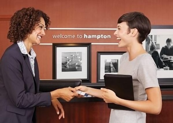 Una recepción con un letrero que dice "welcome to Hampton" y fotografías enmarcadas en la pared.