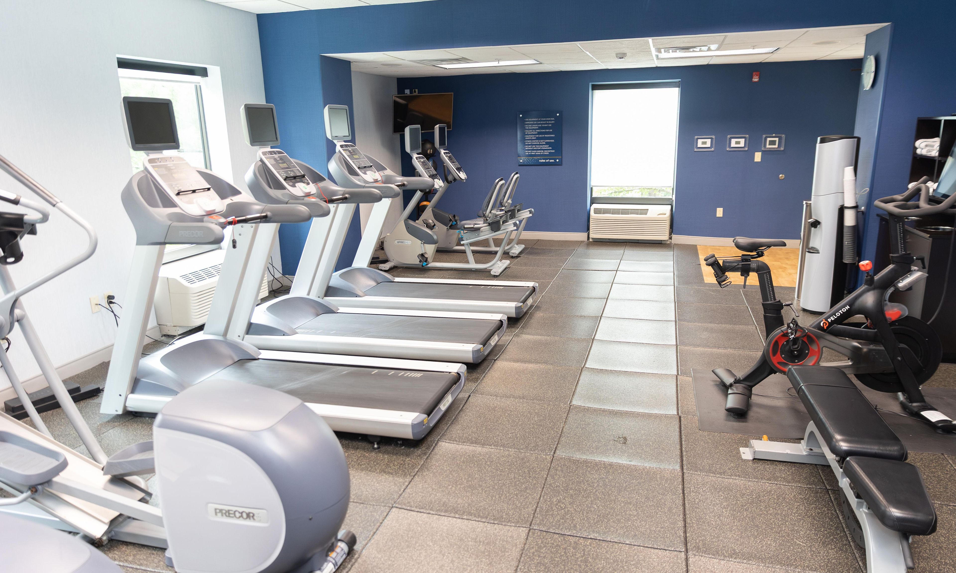 Una palestra con tapis roulant, ellittiche e una bici Peloton.