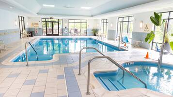 An indoor swimming pool with clear water, multiple lanes, and a lifeguard station.