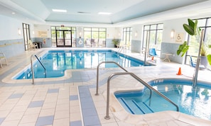 Una piscina interior con agua cristalina, múltiples carriles y una estación de salvavidas.