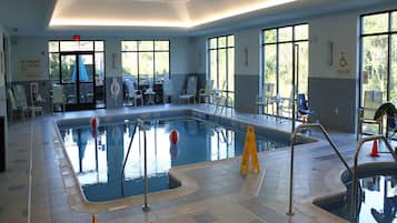 Una piscina techada, sillones reclinables de piscina