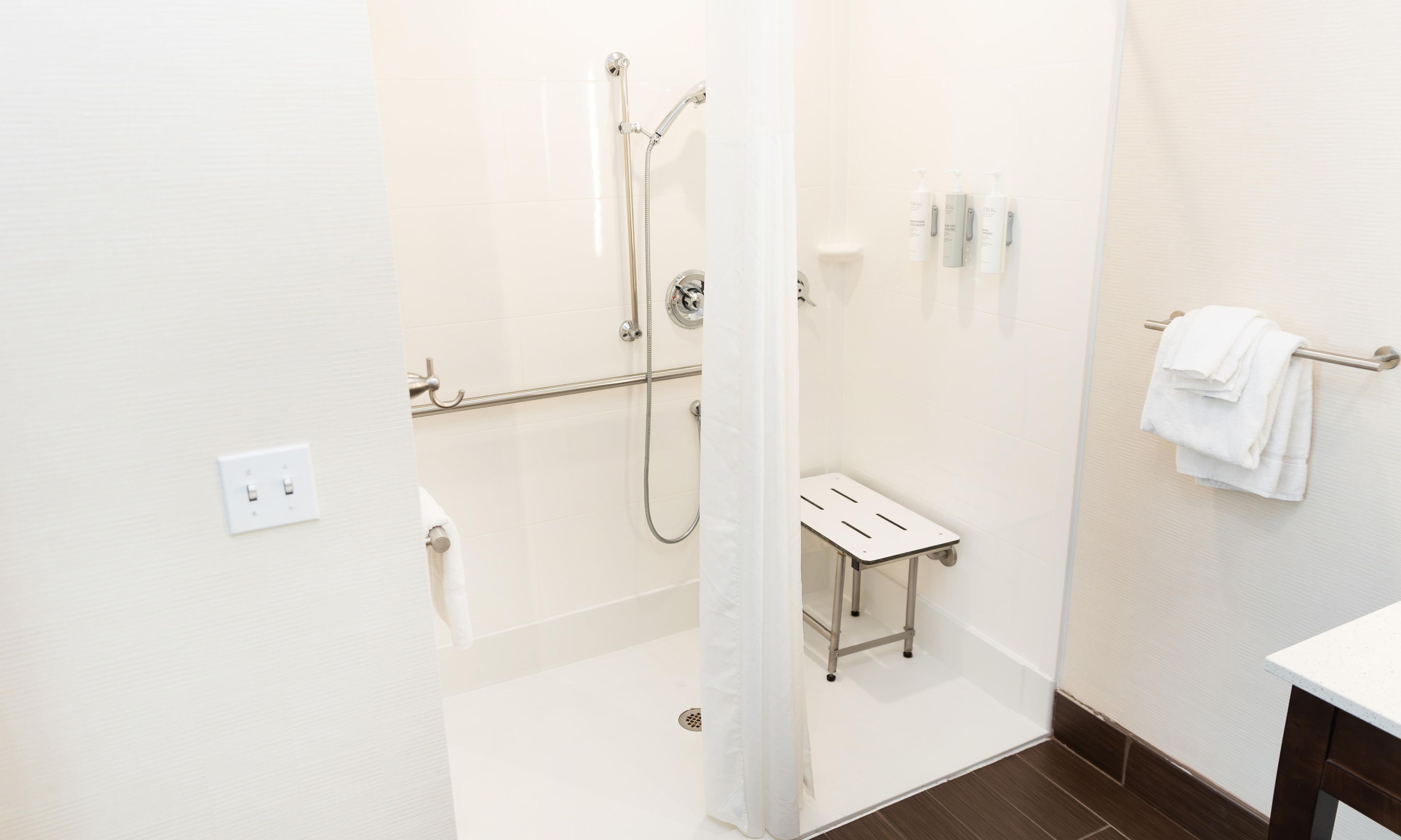 Een moderne badkamer met een douche, toilet en wastafel.