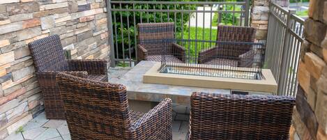 Eine Terrasse mit Korbmöbeln und einer Steinmauer.